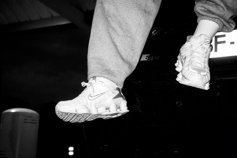 Gros plan sur des baskets blanches et un pantalon de jogging gris